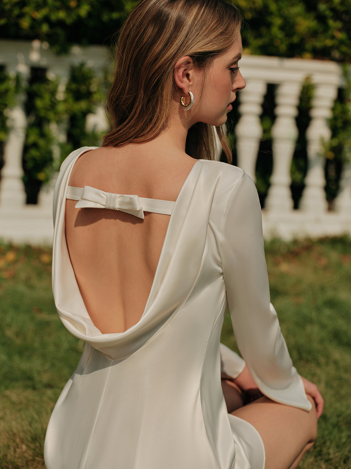 kurzes, rückenfreies Satinkleid mit Schleife und langen Ärmeln