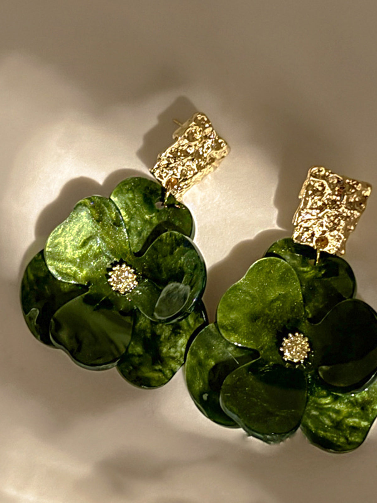 Goldene baumelnde Ohrringe mit Blumenmuster