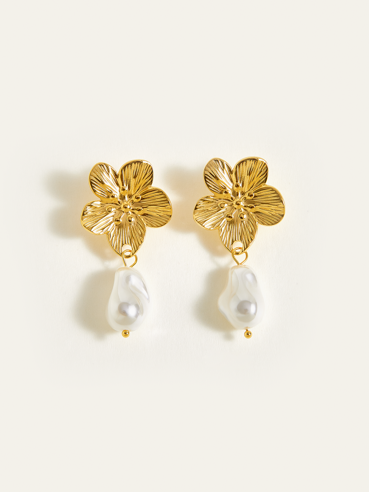 Boucles d'oreilles pendantes dorées à motif floral et perles