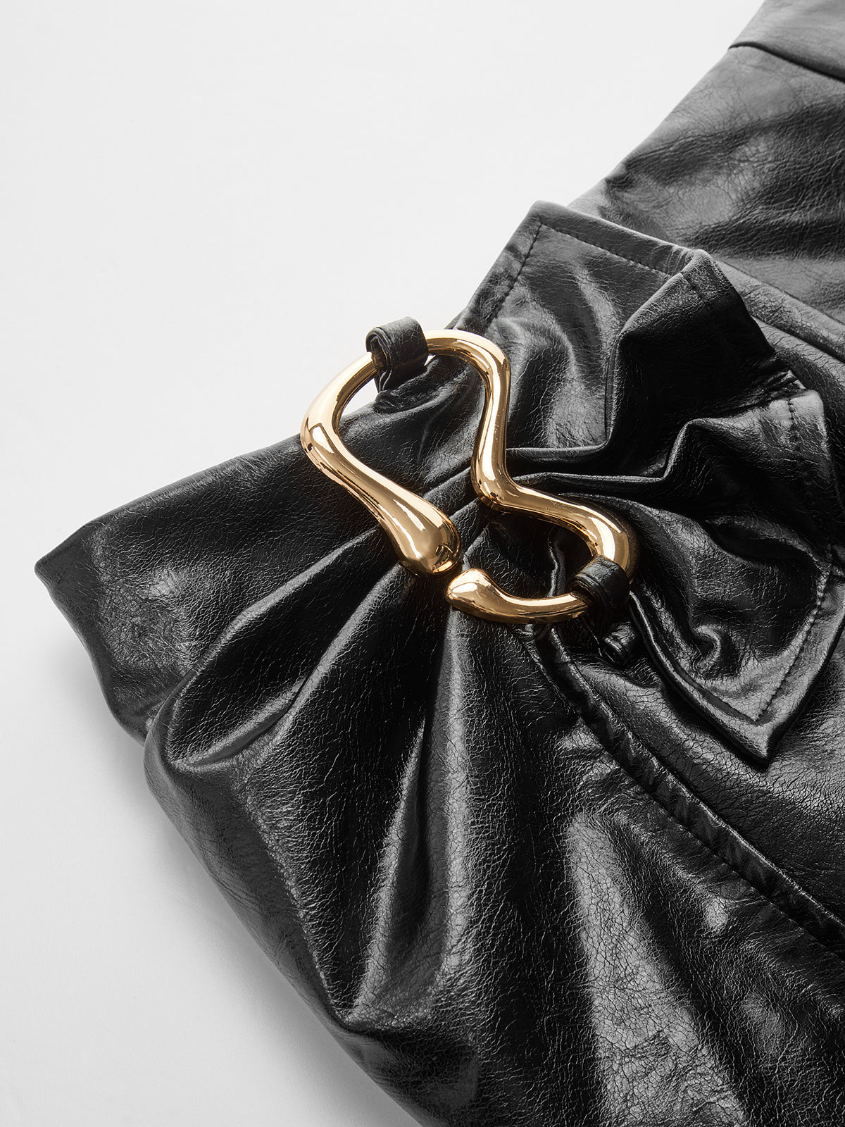 Minirock aus Kunstleder mit Metallschnalle und asymmetrischem Saum