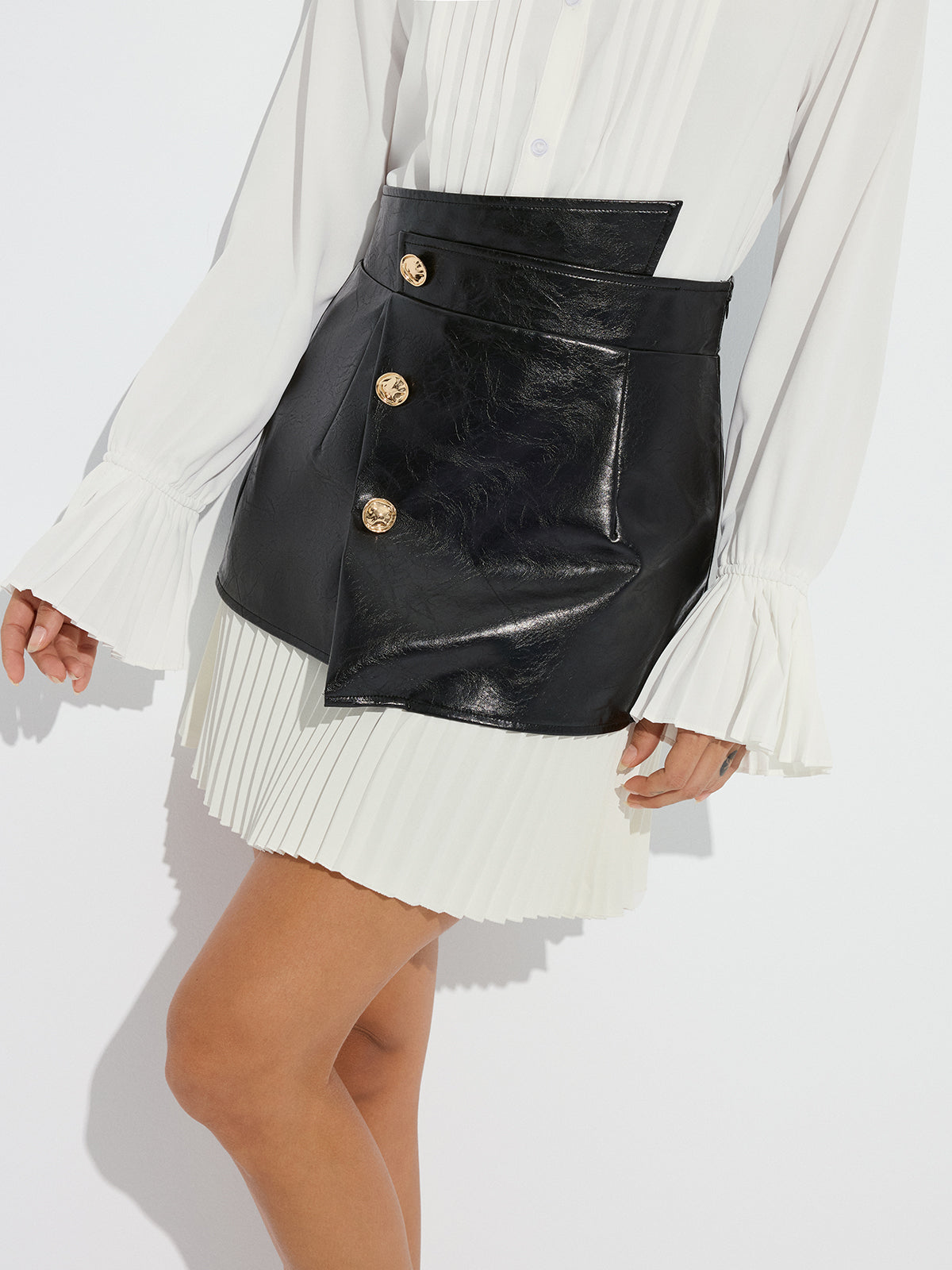 Mini-jupe asymétrique plissée en similicuir