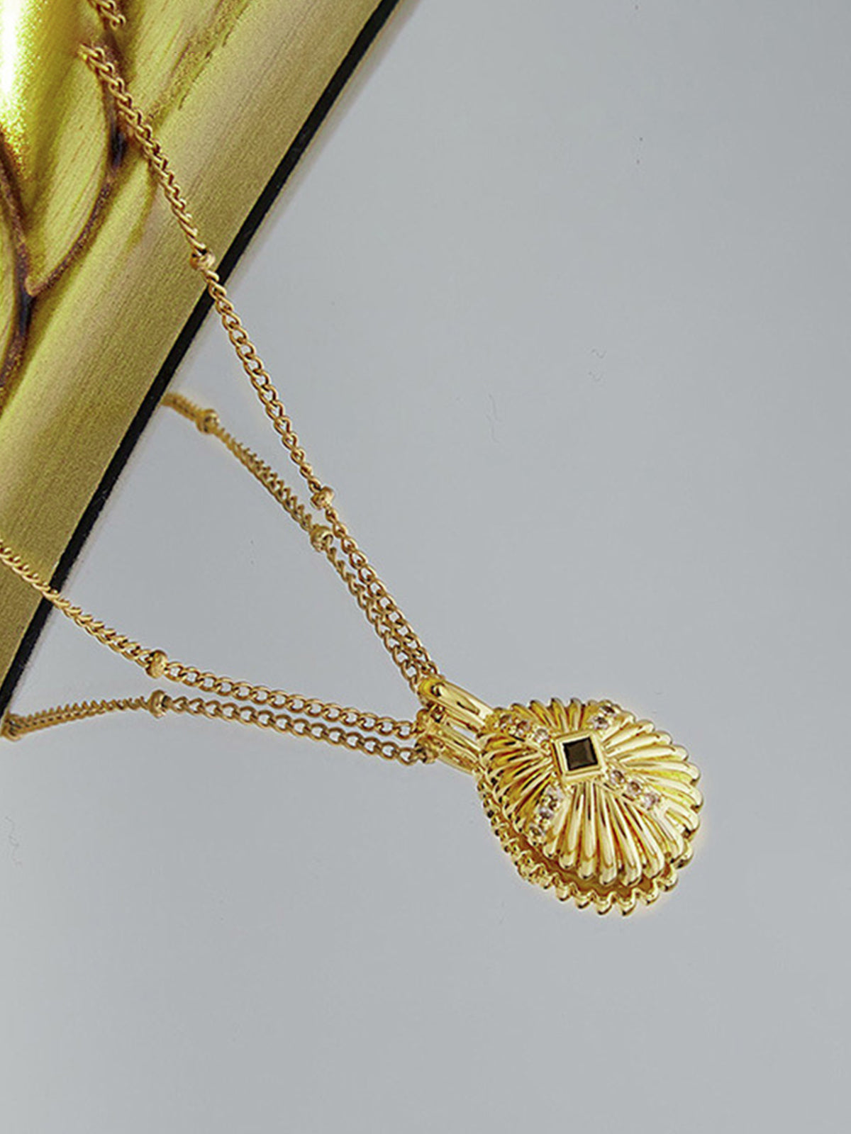 Collier pendentif croix en coquillage serti de diamants