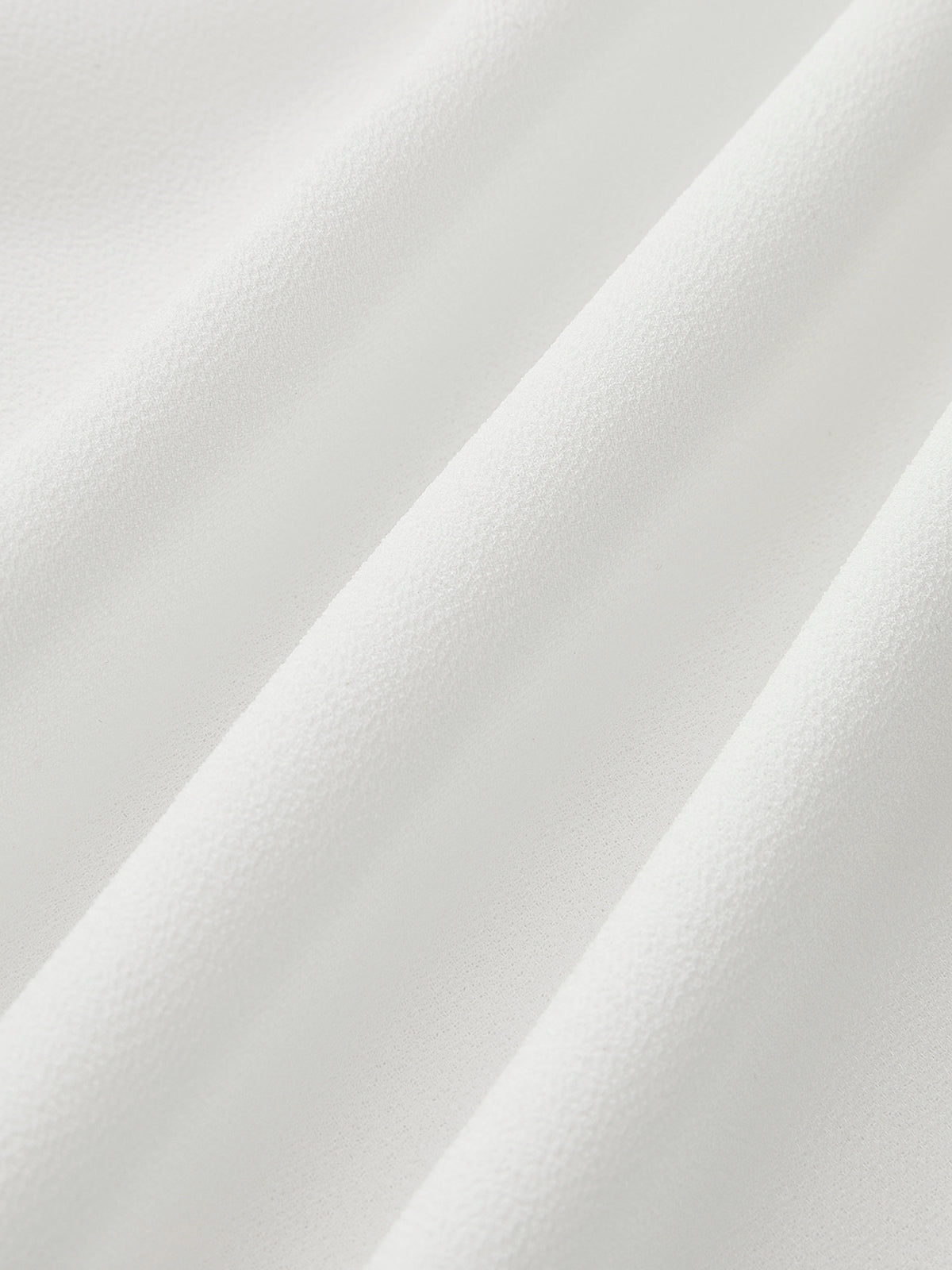 Chemisier semi-transparent à volants et cravate contrastante 