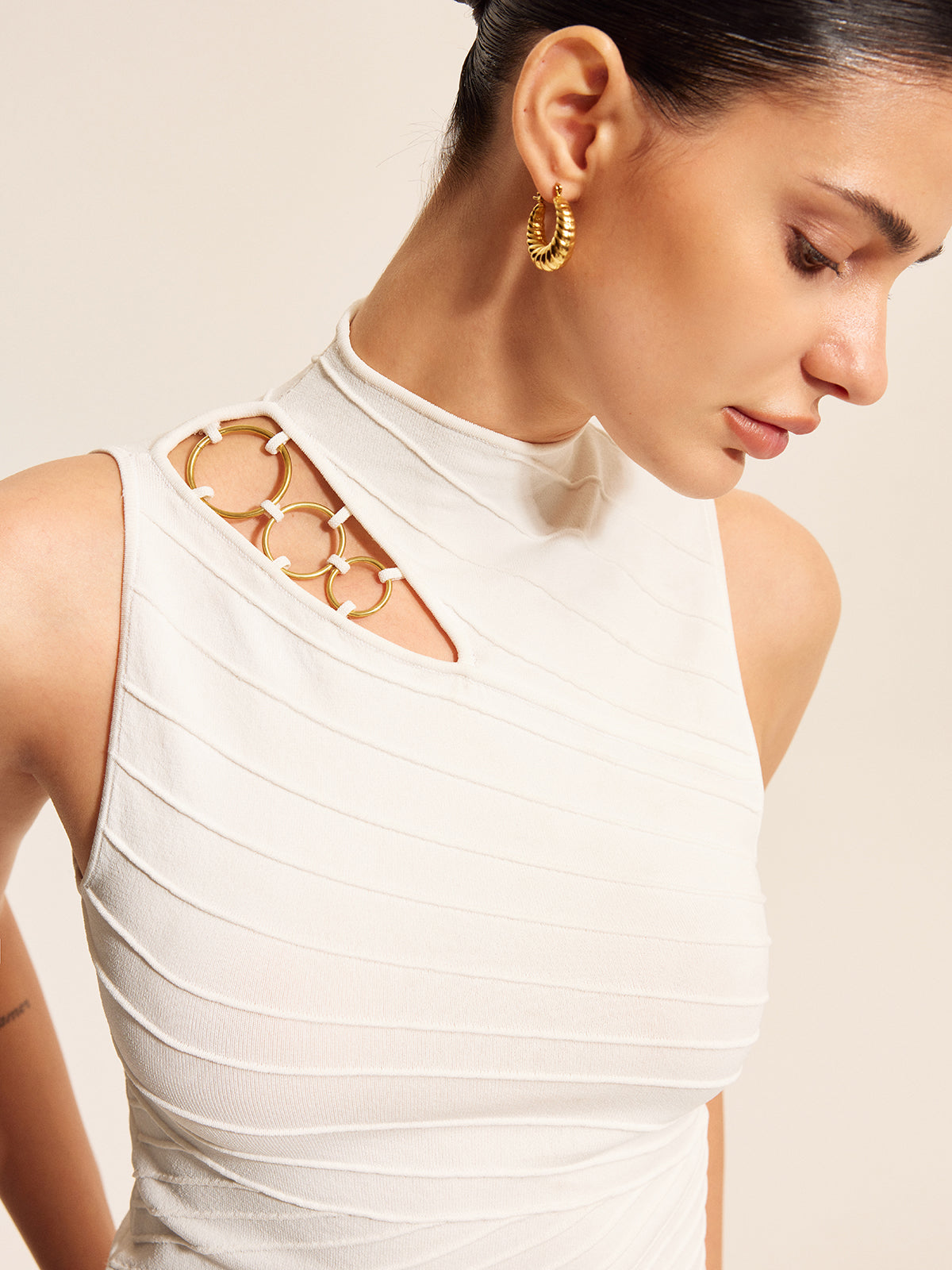 Haut en maille asymétrique à découpes et détails en chaîne 