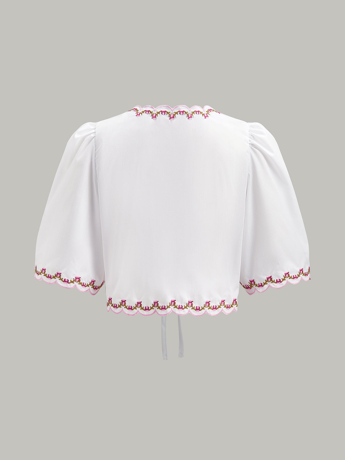 Blouse brodée à manches bouffantes et nœud, ornée de festons et de broderies. 