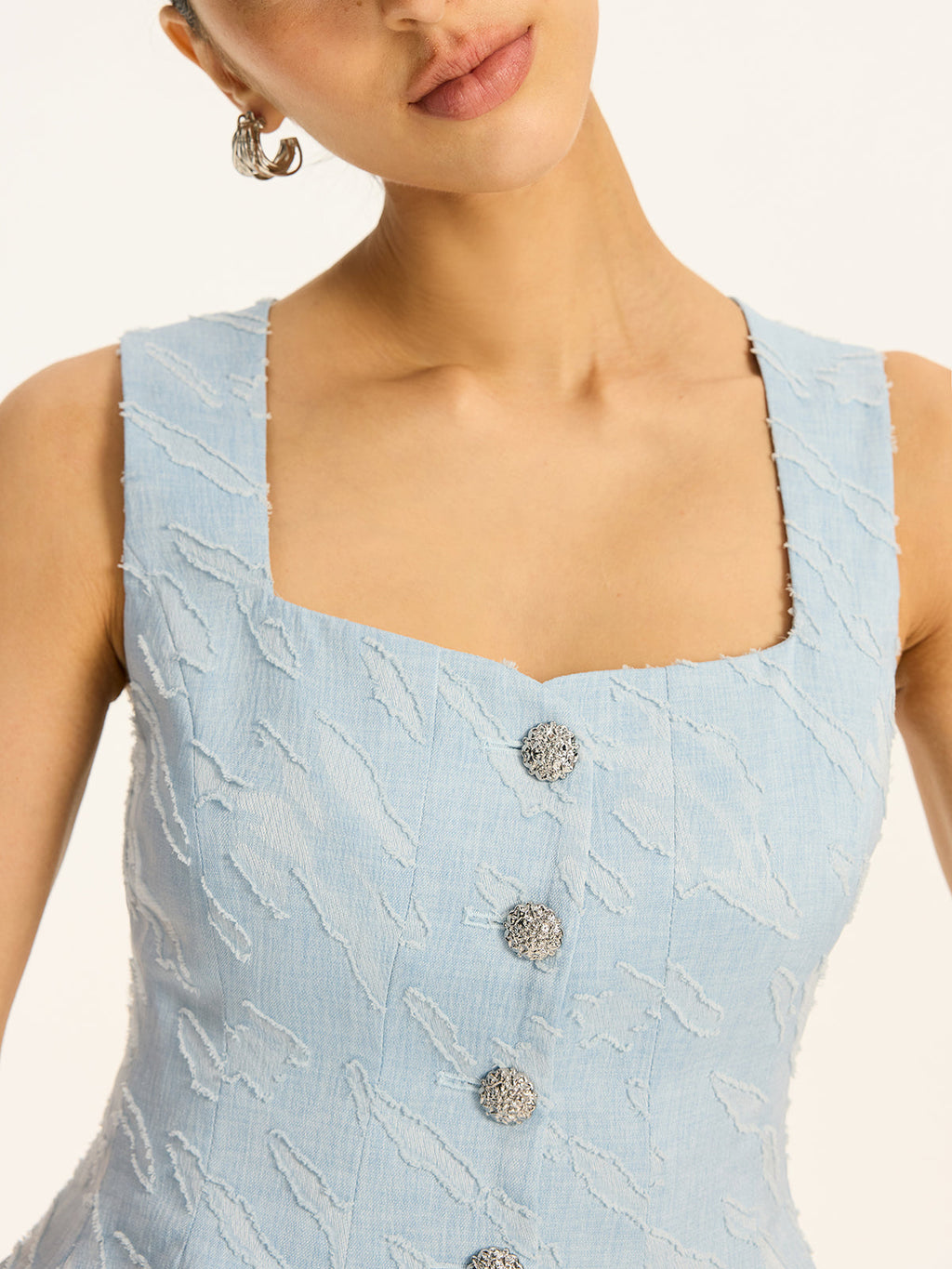 Gilet péplum en tissu texturé avec boutons métalliques