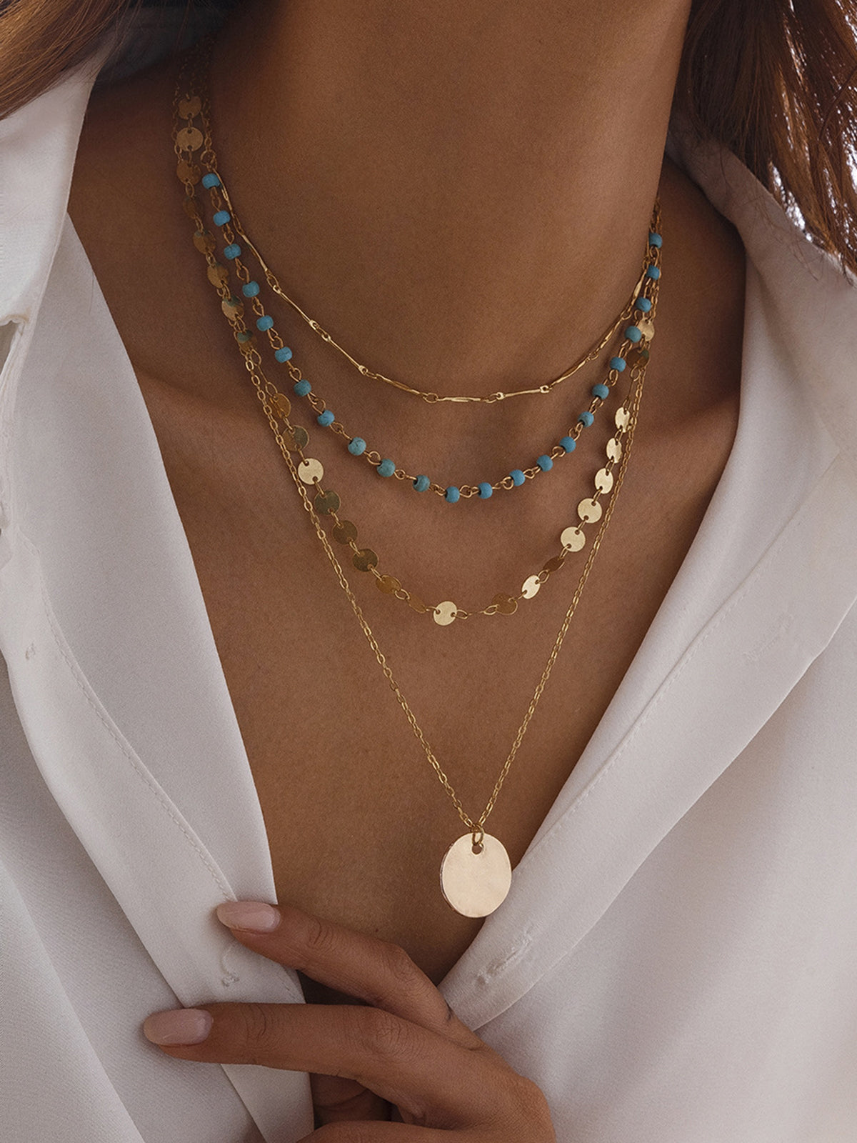 Collier doré à plusieurs rangs avec perles et pendentif disque 