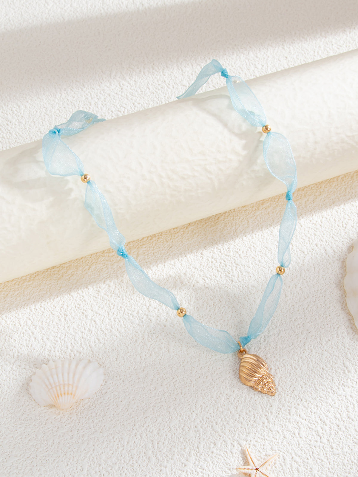 Collier pendentif conque en tulle et perles 