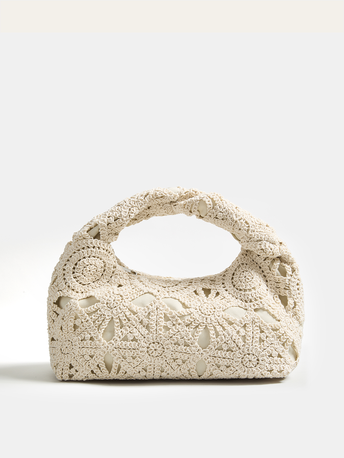 Sac hobo en crochet creux tenu à la main
