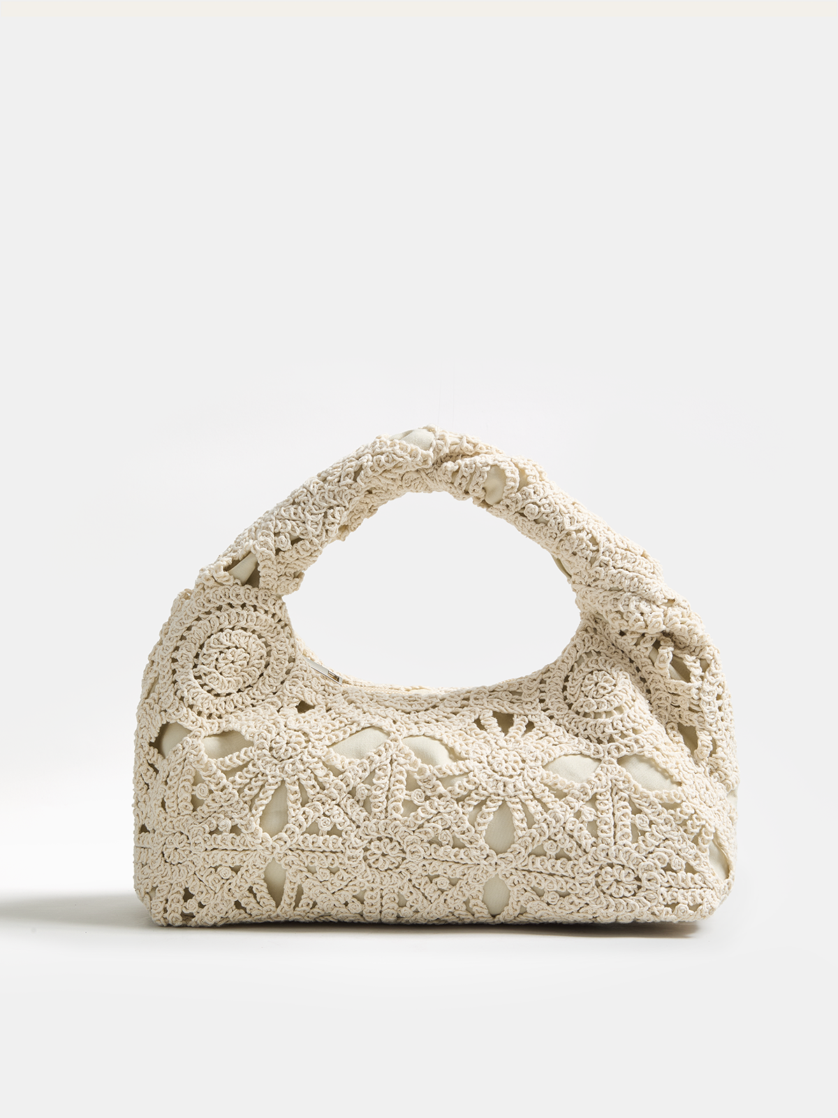Sac hobo en crochet creux tenu à la main